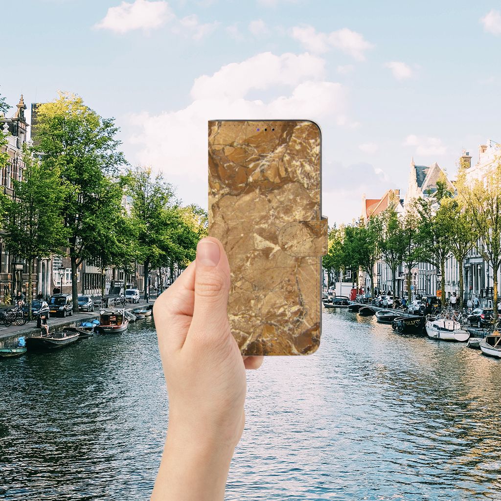 Samsung Galaxy A22 5G Bookcase Marmer Creme in hand with a scenic canal view.