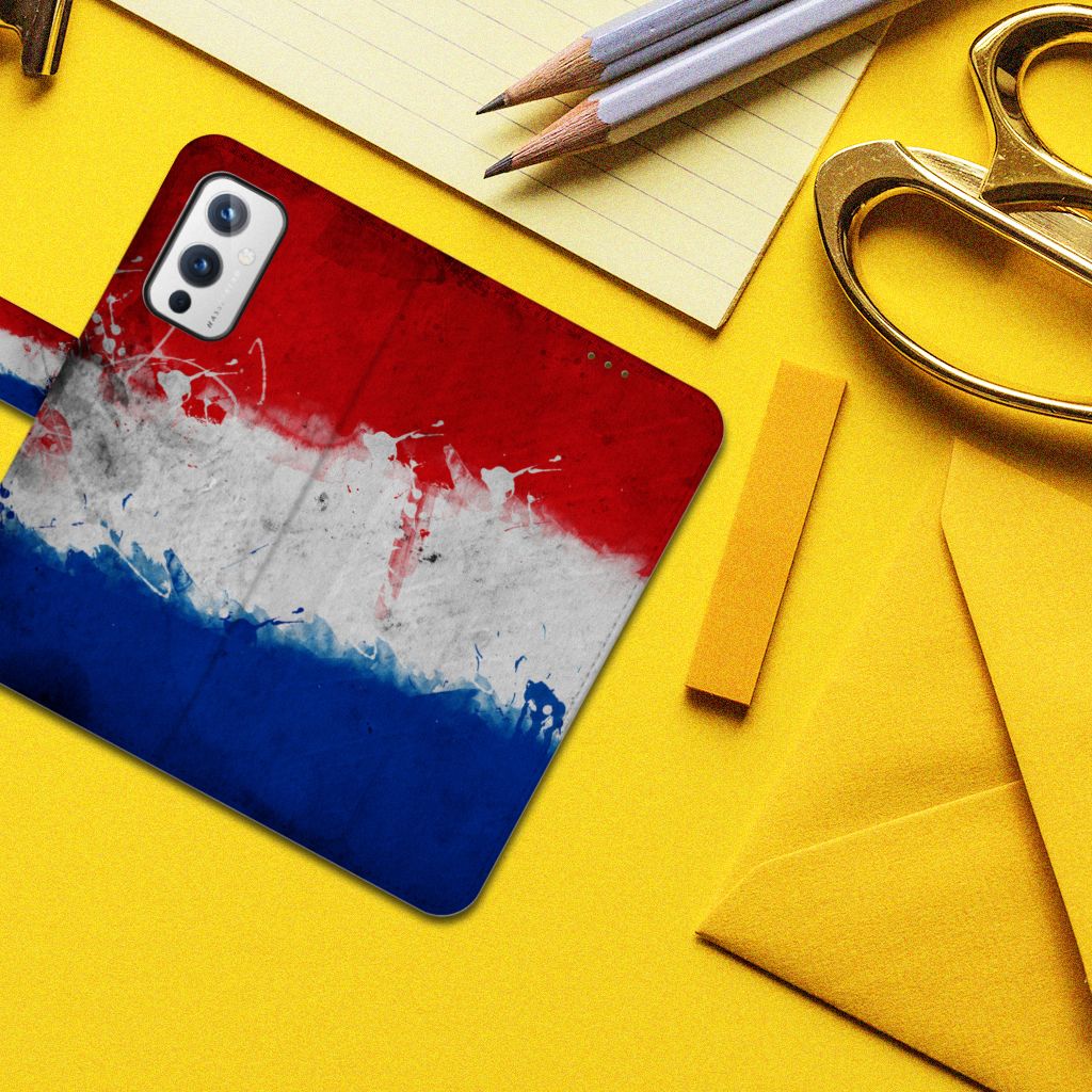 OnePlus 9 Bookstyle Case Nederland met design van de Nederlandse vlag op een bureau met schrijfgerei.