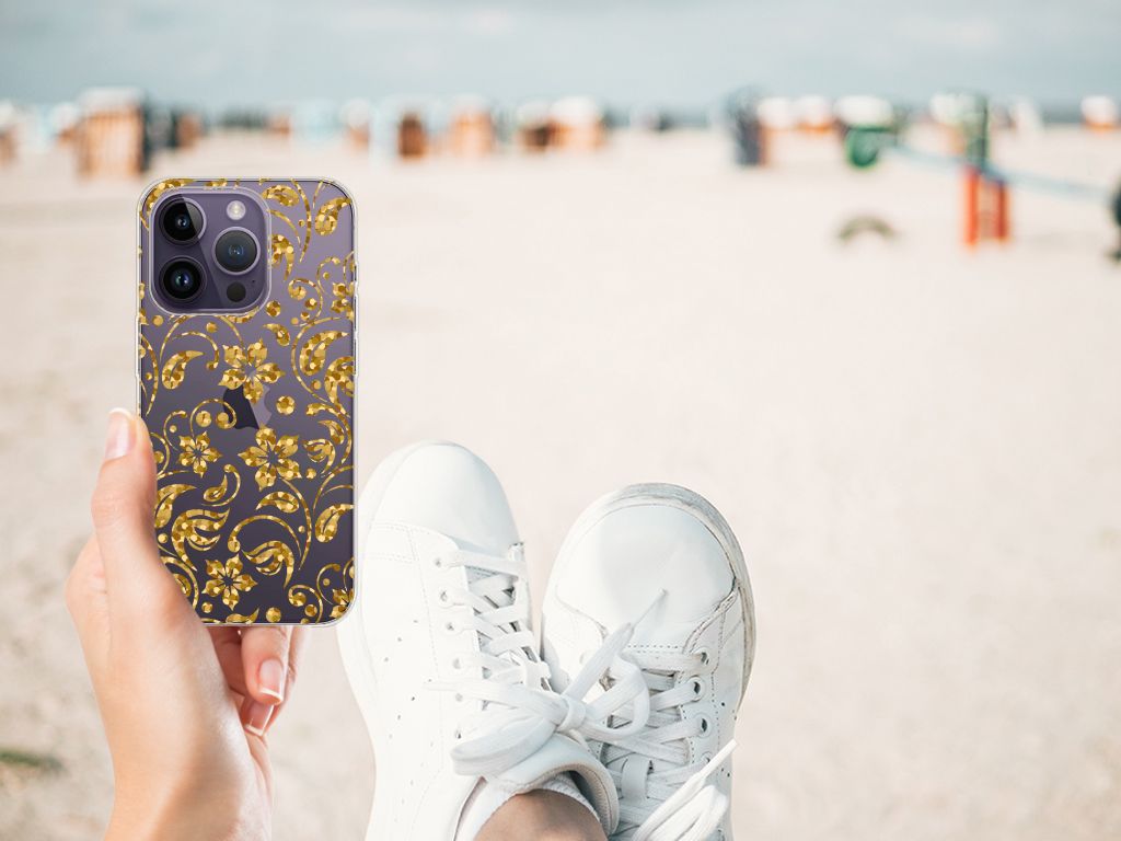 Apple iPhone 14 Pro TPU Case Gouden Bloemen met gouden bloemen design op een strand, casual stijl in hand.