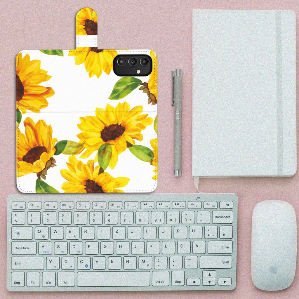 Hoesje voor Samsung Galaxy A14 5G Zonnebloemen met zonnig bloemendesign, liggend op een bureau met accessoires.
