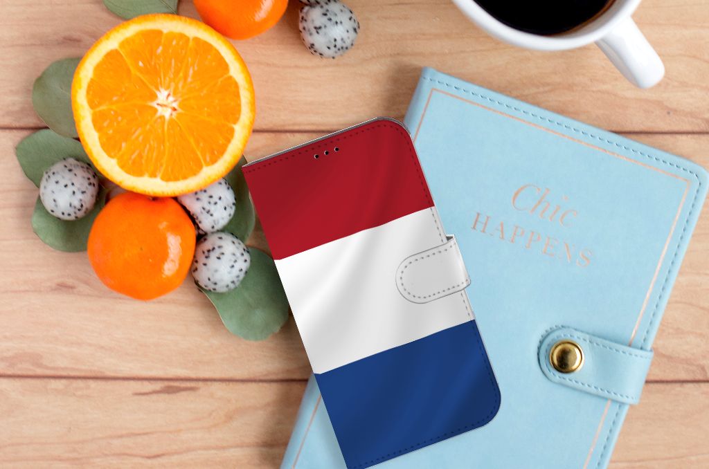 iPhone 14 Plus Bookstyle Case Nederlandse Vlag op een houten tafel met fruit en een notitieboekje.