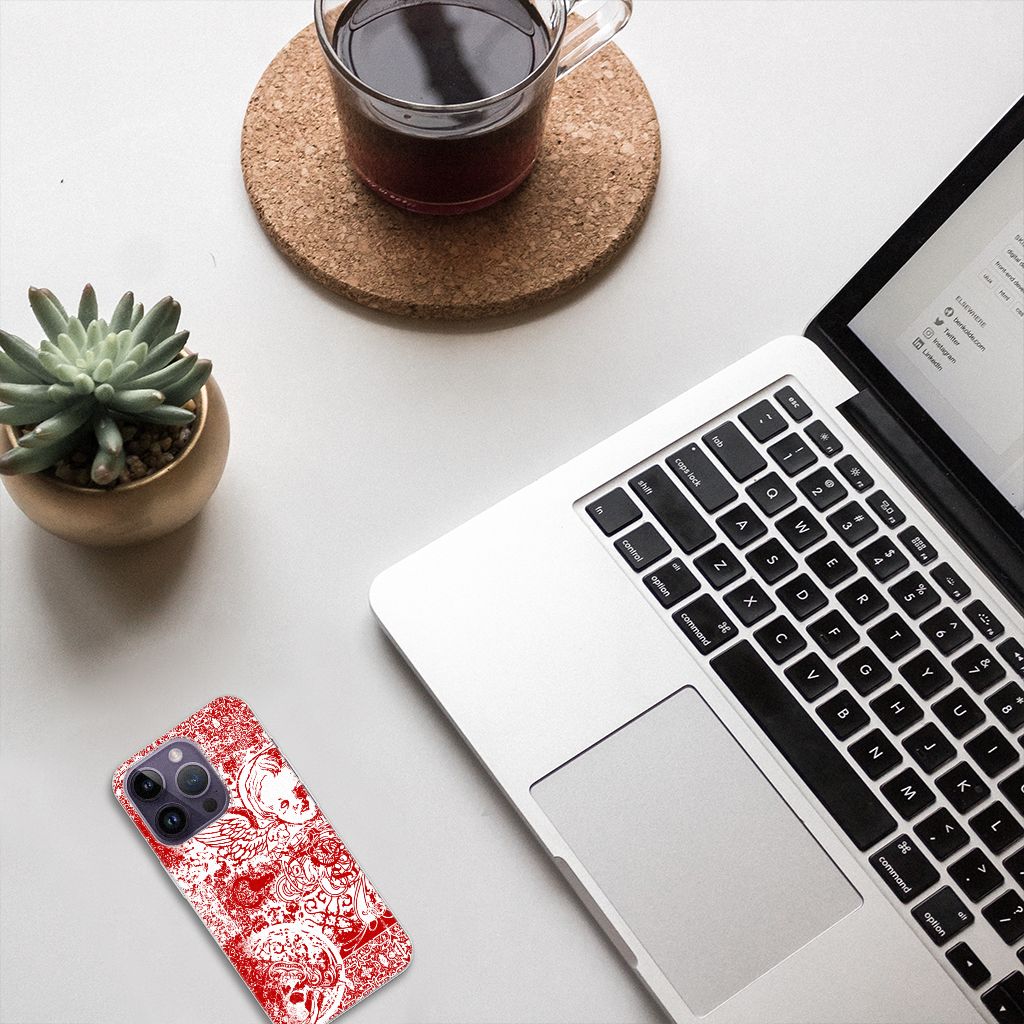 Silicone Back Case Apple iPhone 14 Pro Angel Skull Rood op bureau met laptop en plantaardig decor.