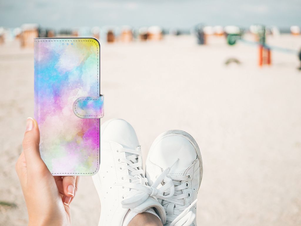 Hoesje OPPO A74 4G Watercolor Light met pastelkleuren in hand bij het strand, sneakers zichtbaar.