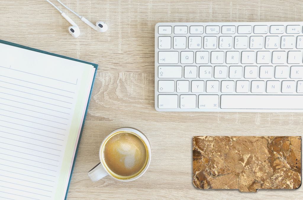 OnePlus 10T Bookcase Marmer Creme op bureau met notitieblok en kopje koffie.