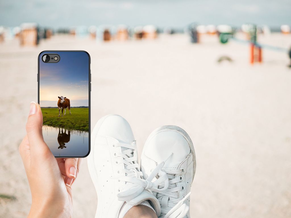 iPhone SE 2022 | SE 2020 | 7/8 Dierenprint Telefoonhoesje Koe met koeienafbeelding op een strandachtergrond.