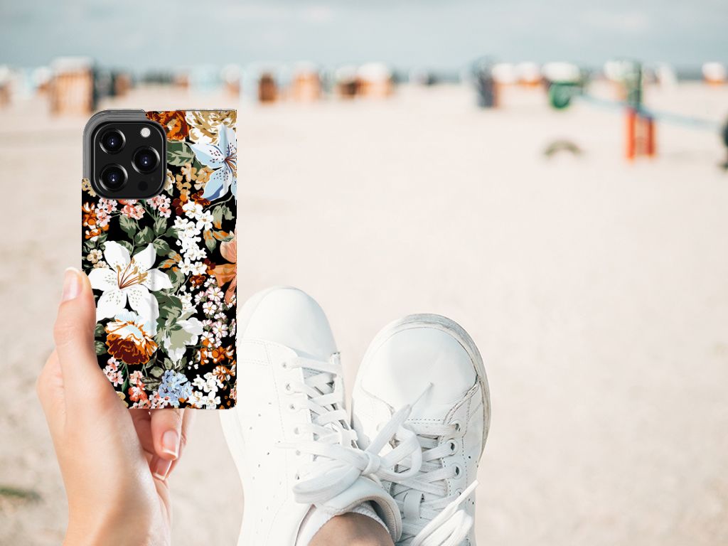 Smart Cover voor iPhone 13 Pro Dark Flowers met bloemenprint op een strand.