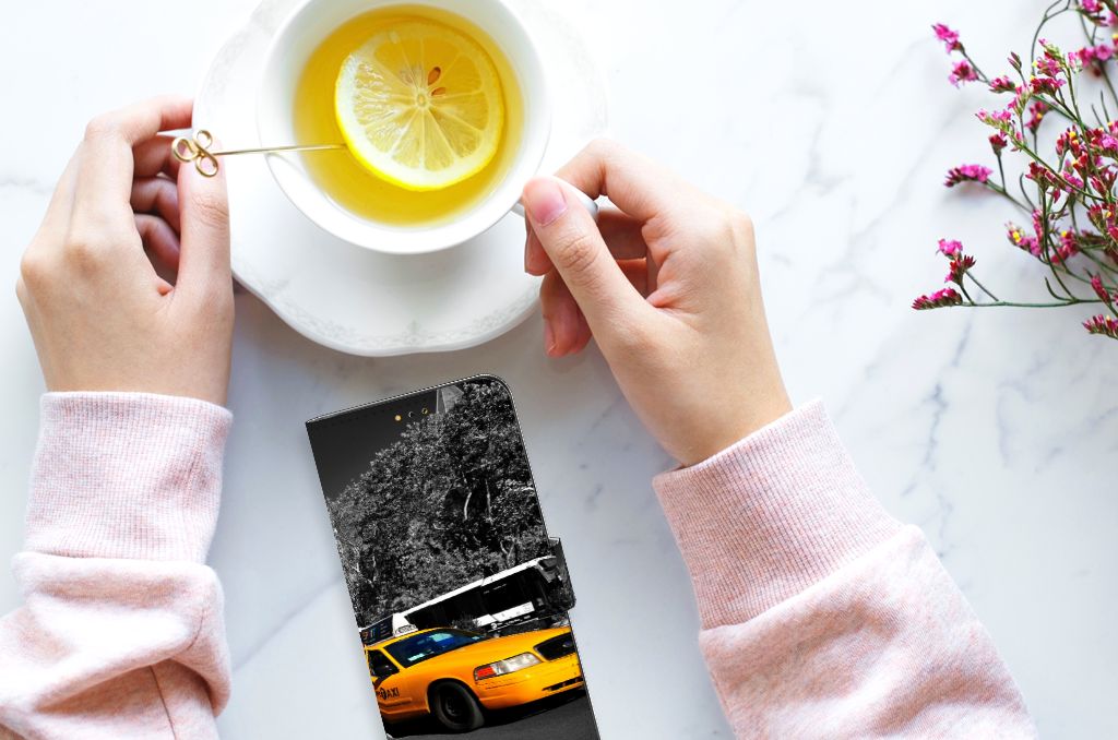 Samsung Galaxy A14 5G Flip Cover New York Taxi on a table next to a cup of tea with lemon.