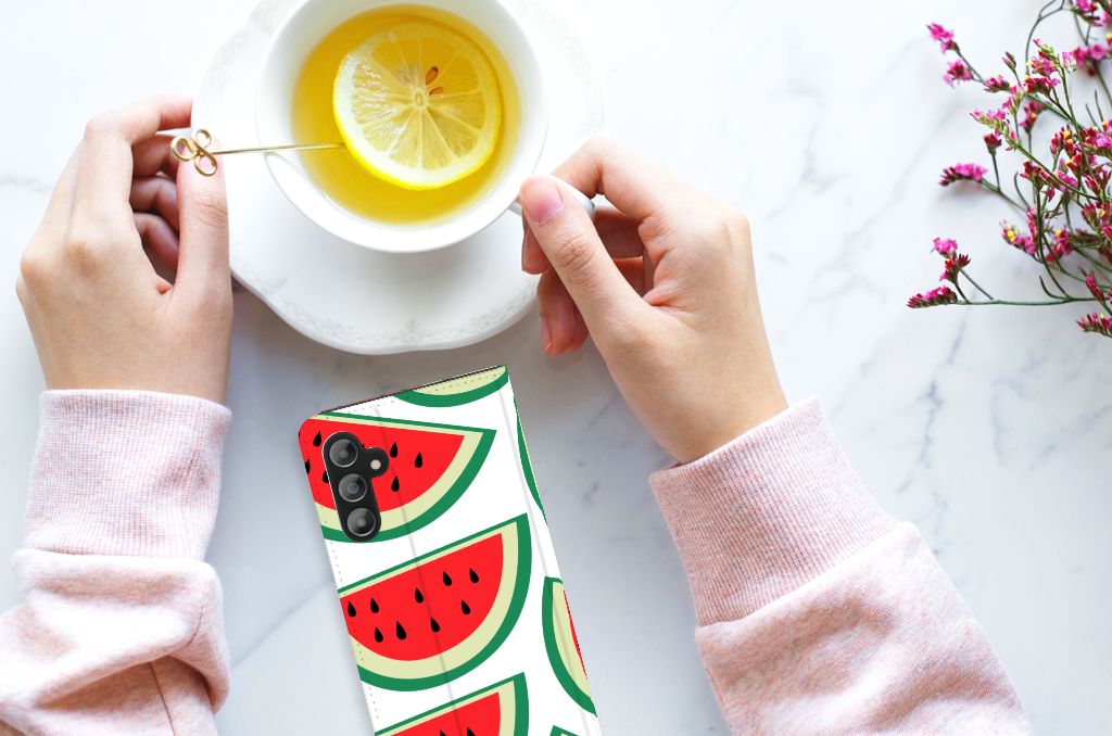Samsung Galaxy A14 5G Flip Style Cover Watermelons next to a cup of tea with lemon and hands.