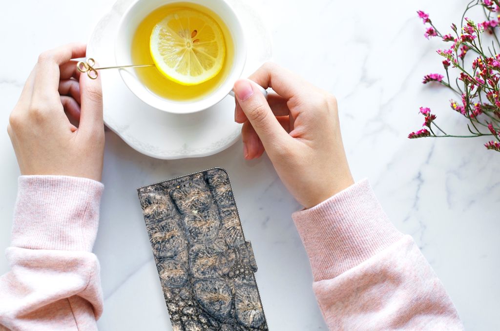 Samsung Galaxy A14 5G Telefoonhoesje met Pasjes Krokodillenprint naast een kopje thee met citroen.