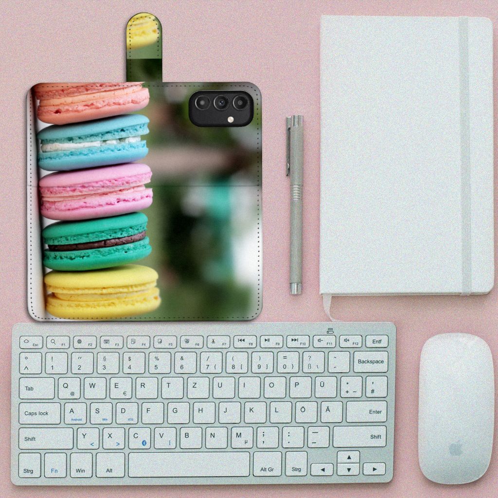 Samsung Galaxy A14 4G Book Cover Macarons met kleurrijke macarons en een toetsenbord op een bureau.