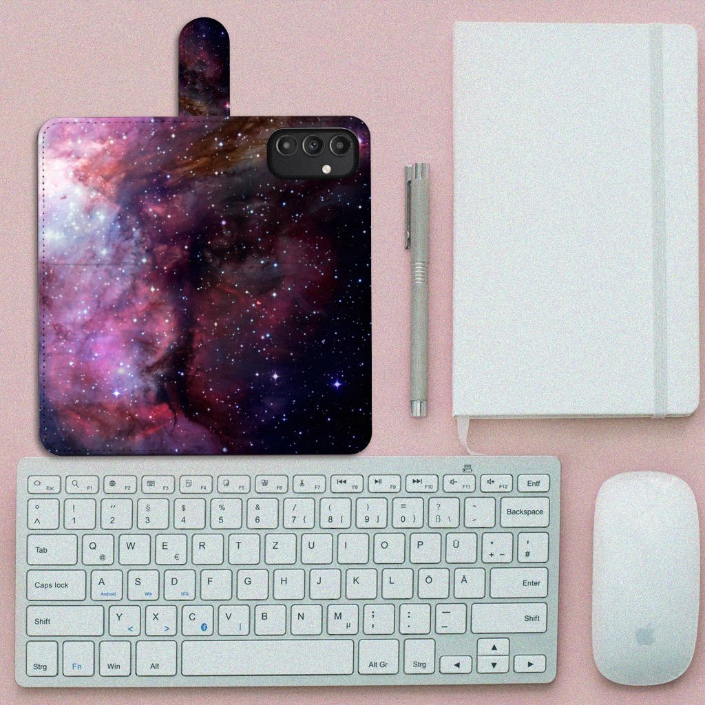 Book Case voor Samsung Galaxy A14 4G Galaxy met een heelal design op een bureau met accessoires.