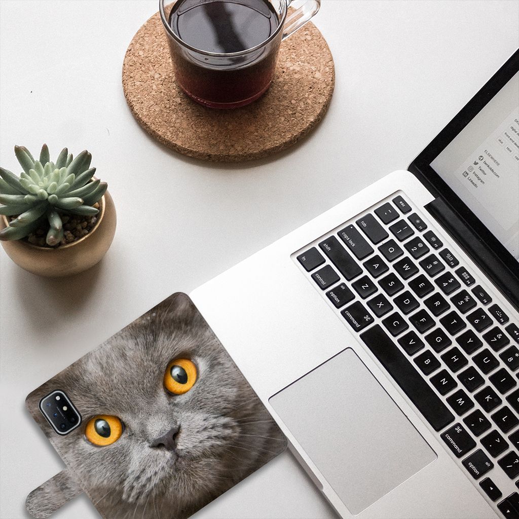 Telefoonhoesje met Pasjes OnePlus 8T Britse Korthaar op een bureau met laptop en groen plantje.