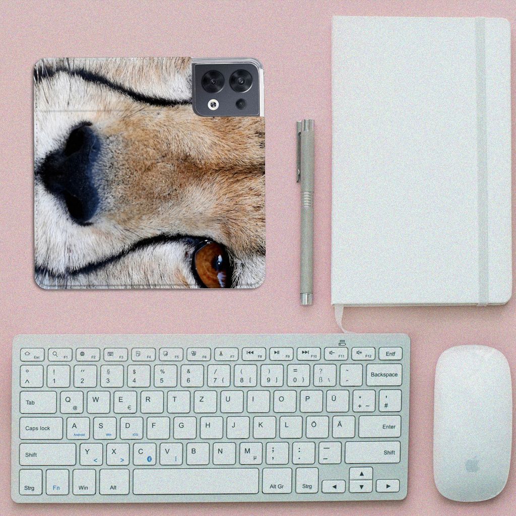 OPPO Reno8 Hoesje maken Cheetah met close-up van een jachtluipaard op een bureau met toetsenbord en notitieboek.