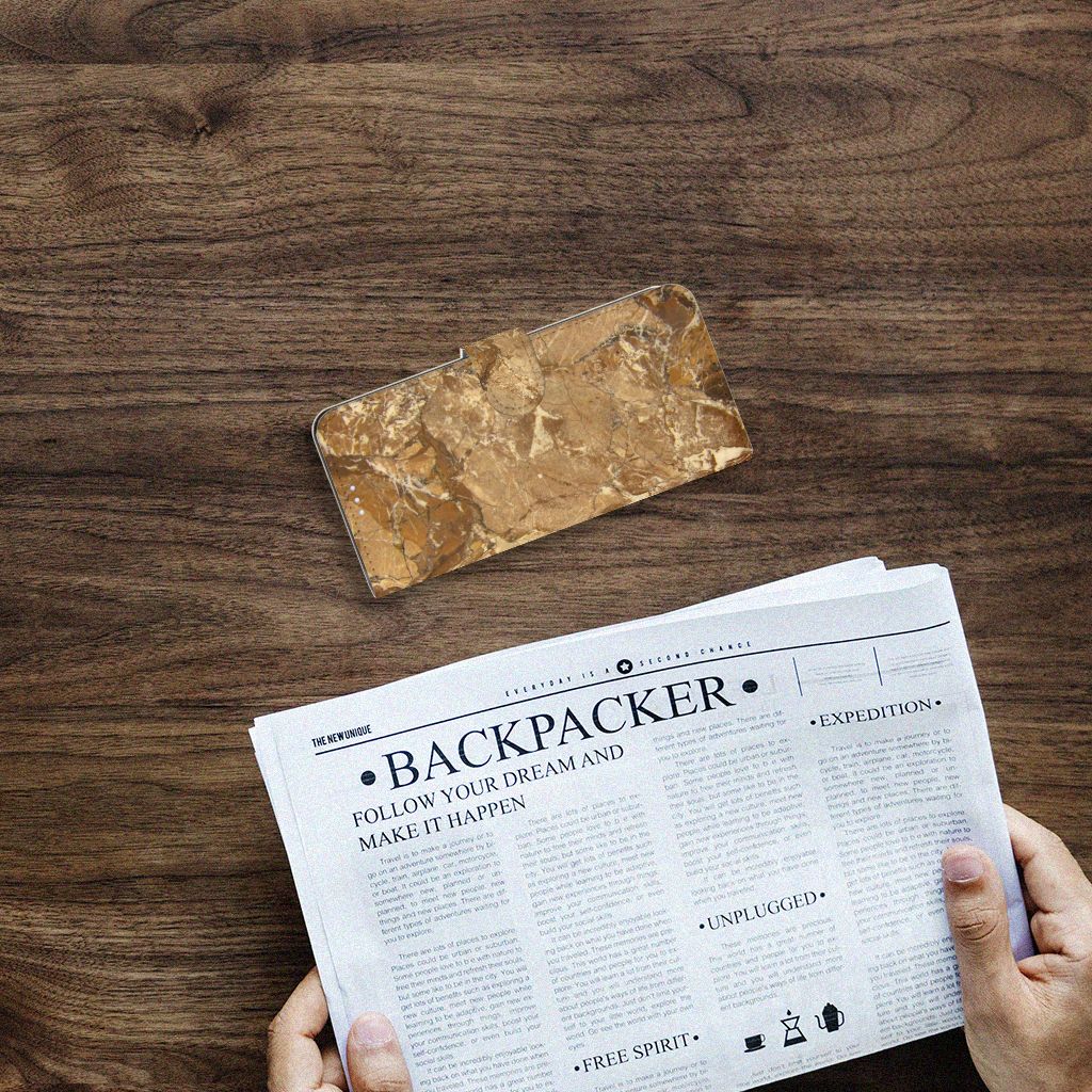 Motorola Moto G100 Bookcase Marmer Creme op houten tafel met krant ernaast.