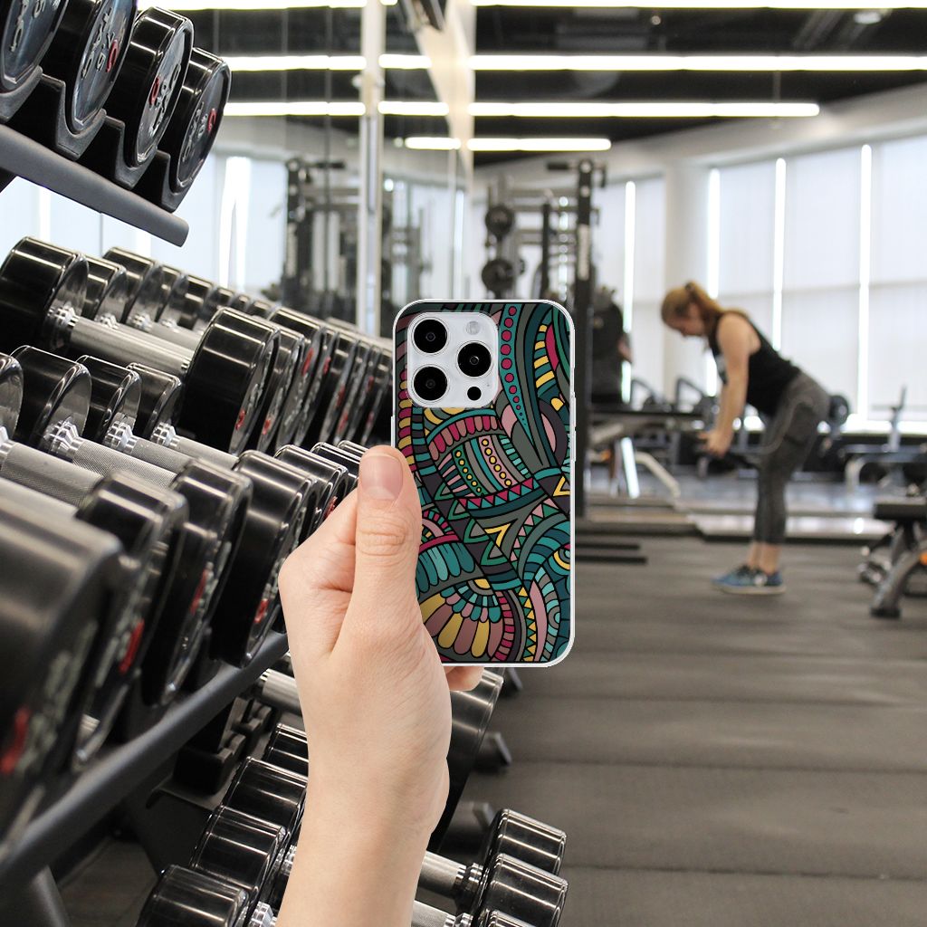 Hand holding an iPhone 15 Pro TPU bumper Aztec design in a gym with weights.
