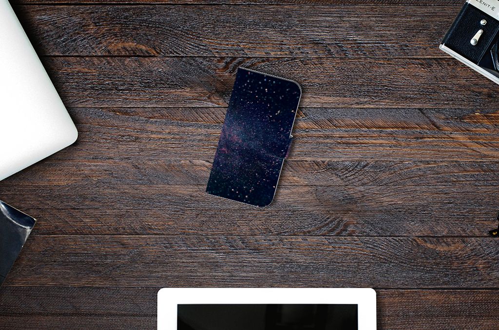 iPhone 14 Pro Book Case Stars op een houten tafel met een sterrenhemel design en andere tech accessoires.