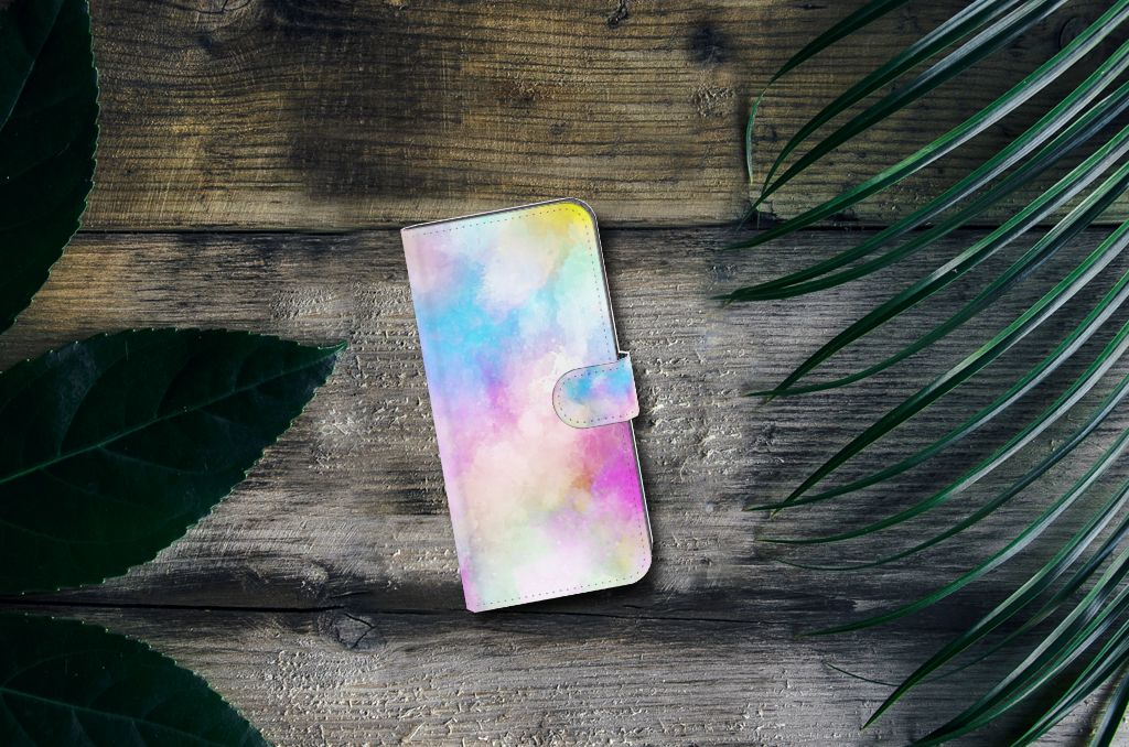Hoesje Nokia C12 Watercolor Light met pastelkleuren op een houten ondergrond omringd door groene bladeren.