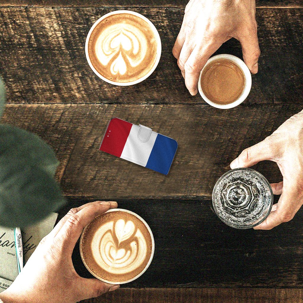 Samsung Galaxy S22 Bookstyle Case Nederlandse Vlag op tafel met koffiekoppen, geserveerd bij een gezellig samenzijn.