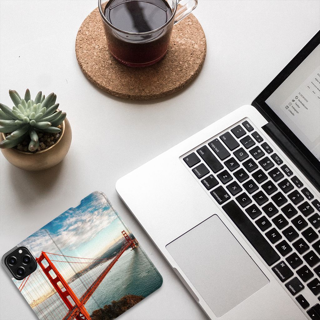 iPhone 13 Pro Max Book Cover Golden Gate Bridge on a desk with a laptop and coffee.