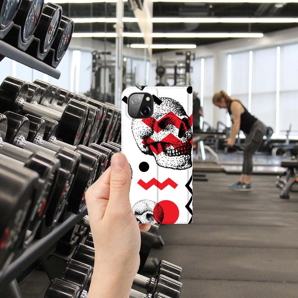 Mobiel BookCase Apple iPhone 14 Plus Skull Red in een sportschool met dumbbells op de achtergrond.