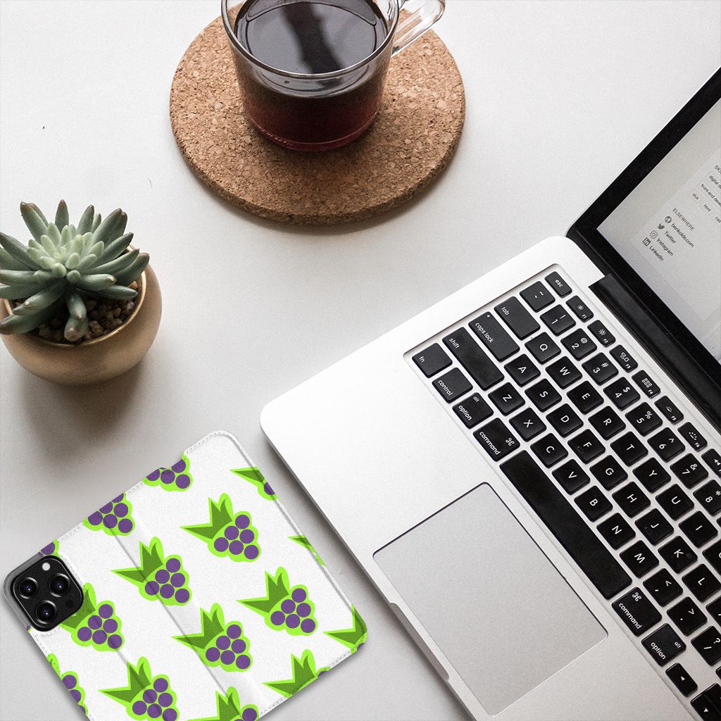 iPhone 13 Pro Max Flip Style Cover Druiven met paarse druiven motief op bureau met laptop en planten.