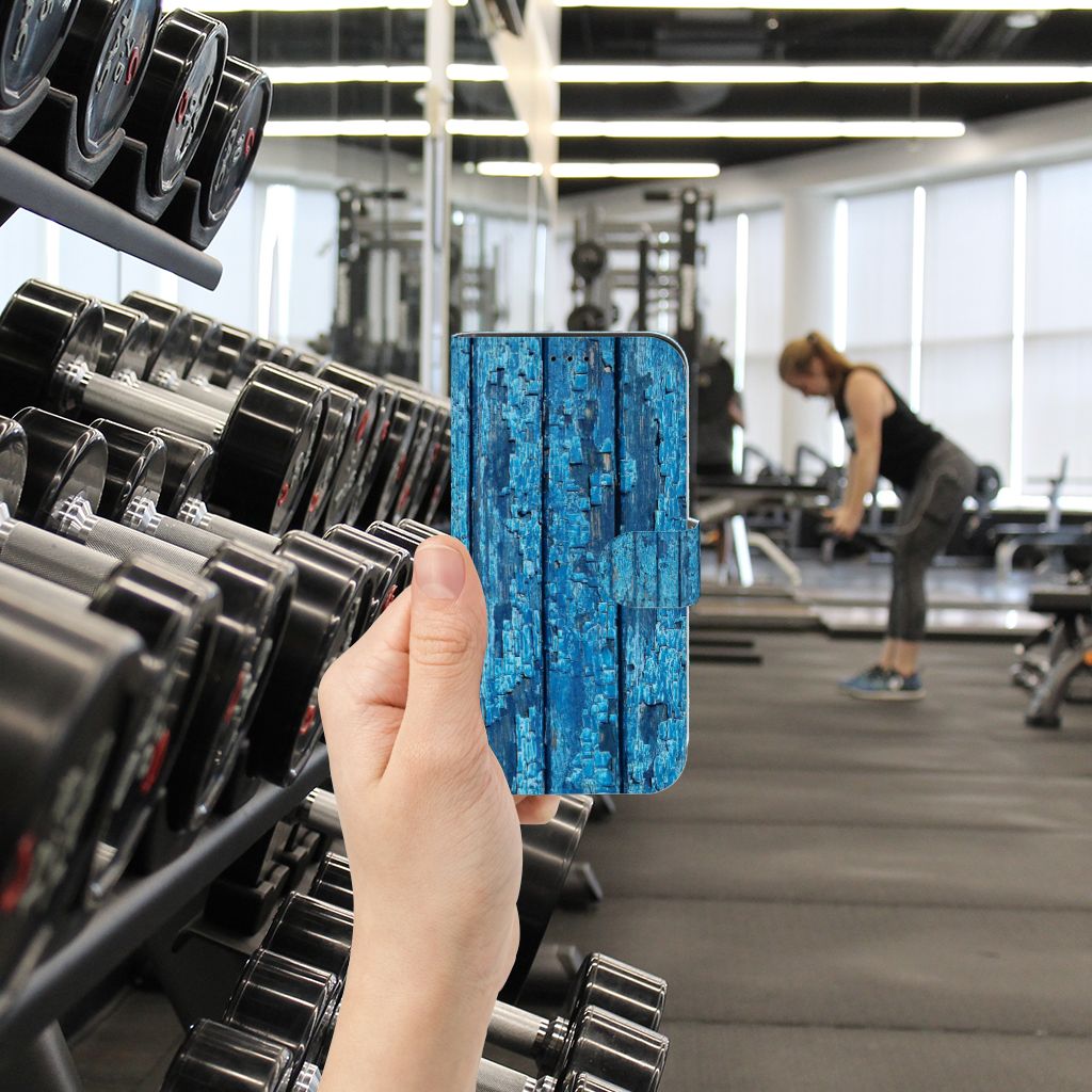 iPhone 13 Pro Book Style Case Wood Blue in hand at the gym, showcasing its unique blue wood design.
