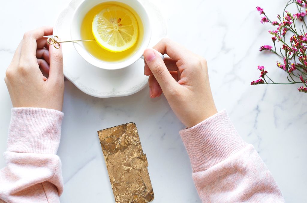 Xiaomi 11T | 11T Pro Bookcase Marmer Creme naast een kopje thee met citroen op een marmeren tafel.