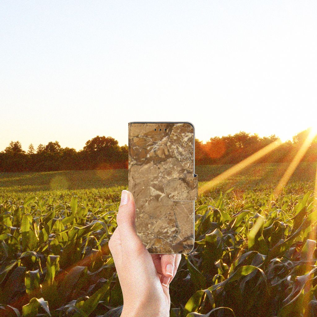 Xiaomi Mi 9 SE Bookcase Marmer Creme in hand against a sunny field backdrop.