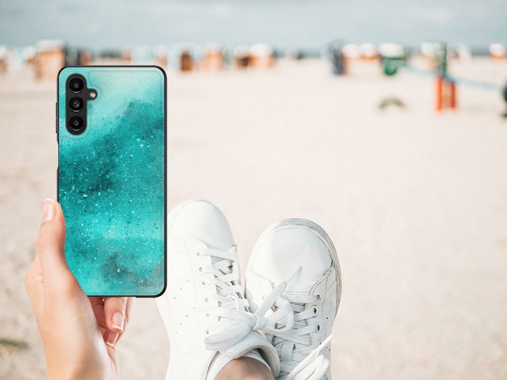 Kleurrijke Telefoonhoesje Samsung Galaxy A14 5G Painting Blue in hand met sneakers op strand