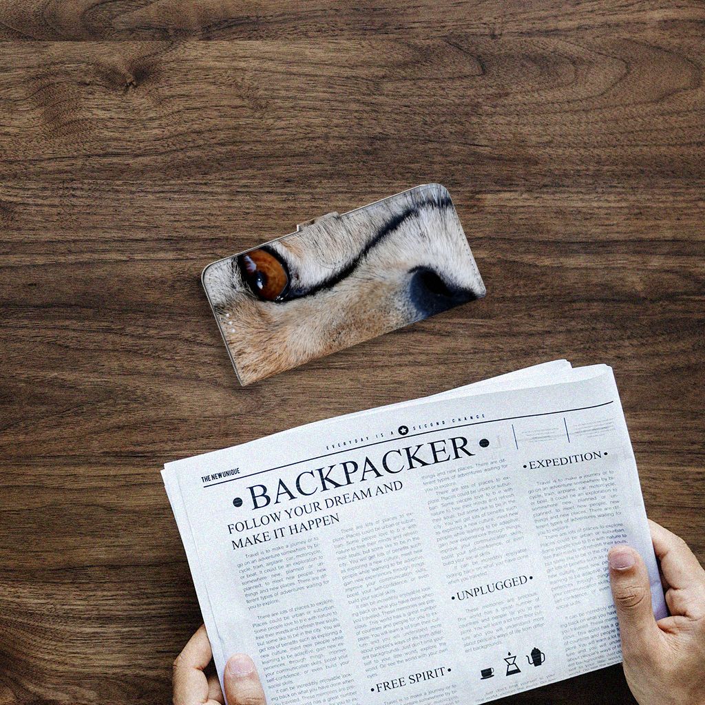 Motorola Moto G100 Telefoonhoesje met Pasjes Cheetah op een houten tafel met een krant eronder.