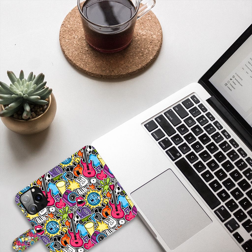 iPhone 14 Pro Wallet Case met Pasjes Punk Rock met kleurrijke gitaardesigns op een bureau met laptop en planten