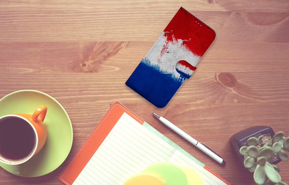 Motorola Moto G60s Bookstyle Case Nederland met artistieke Nederlandse vlag op een bureau met koffie en notities.
