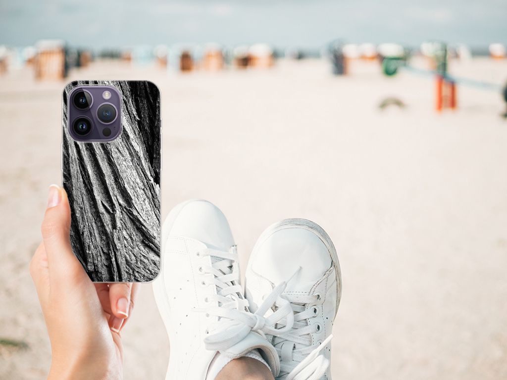 Bumper Hoesje Apple iPhone 14 Pro Boomschors Grijs in hand op het strand met sportieve sneakers.