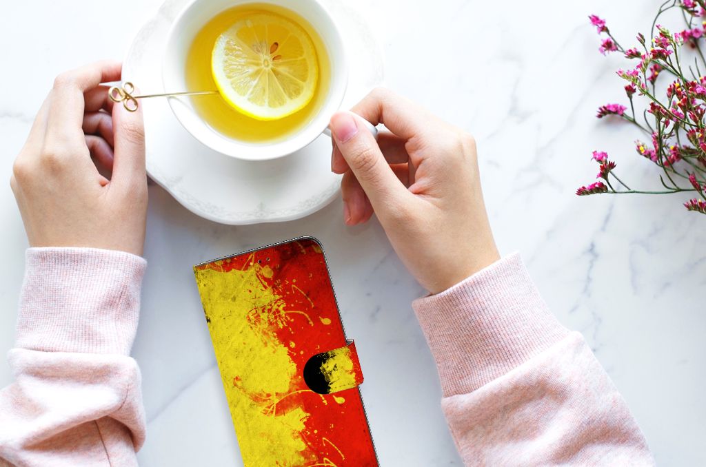 Samsung Galaxy A14 5G Bookstyle Case België met Belgische kleuren, hand met kop thee op tafel.