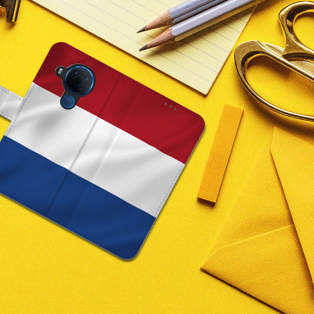 Nokia 5.4 Bookstyle Case Nederlandse Vlag in een kleurrijke setting met gele achtergrond.