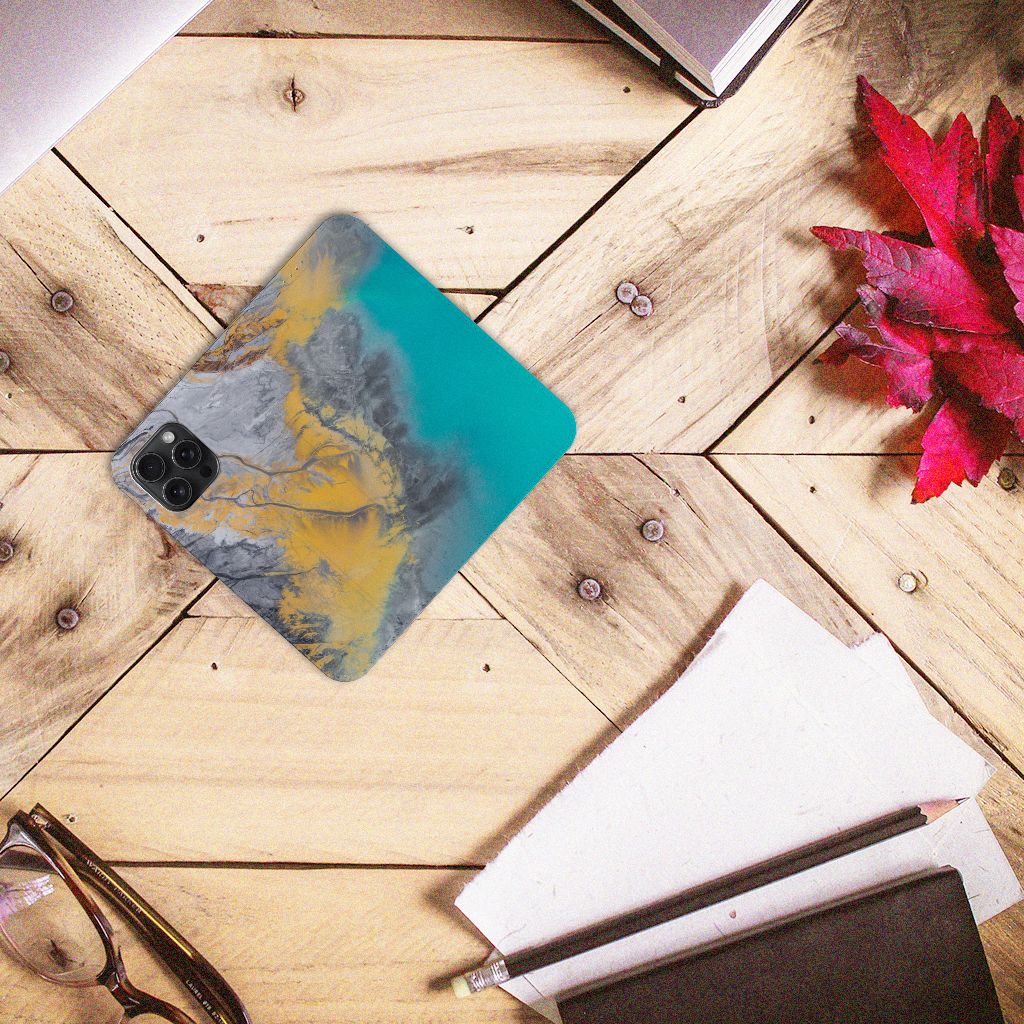 iPhone 15 Pro Max Standcase Marble Blue Gold op een houten tafel met planten en kantoorbenodigdheden.
