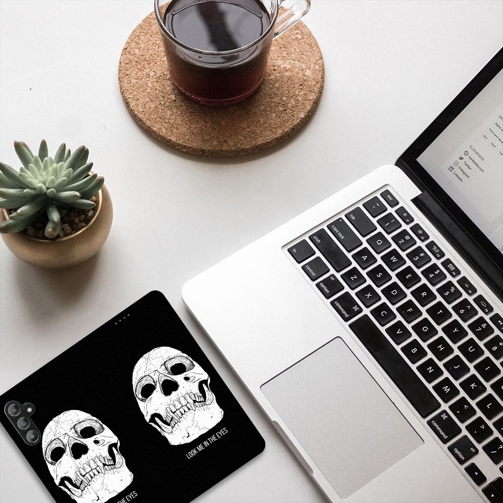 Mobiel BookCase Samsung Galaxy A14 5G Skull Eyes design displayed on a desk with a laptop and coffee.