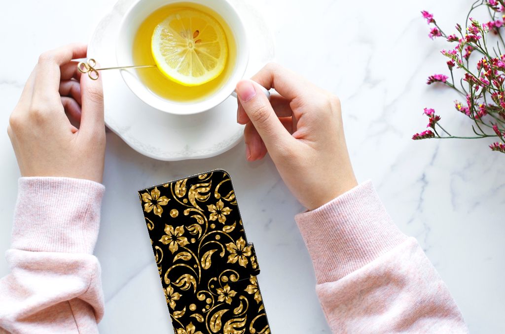 Samsung Galaxy A14 5G Hoesje Gouden Bloemen met gouden bloemenmotief naast een kopje thee.