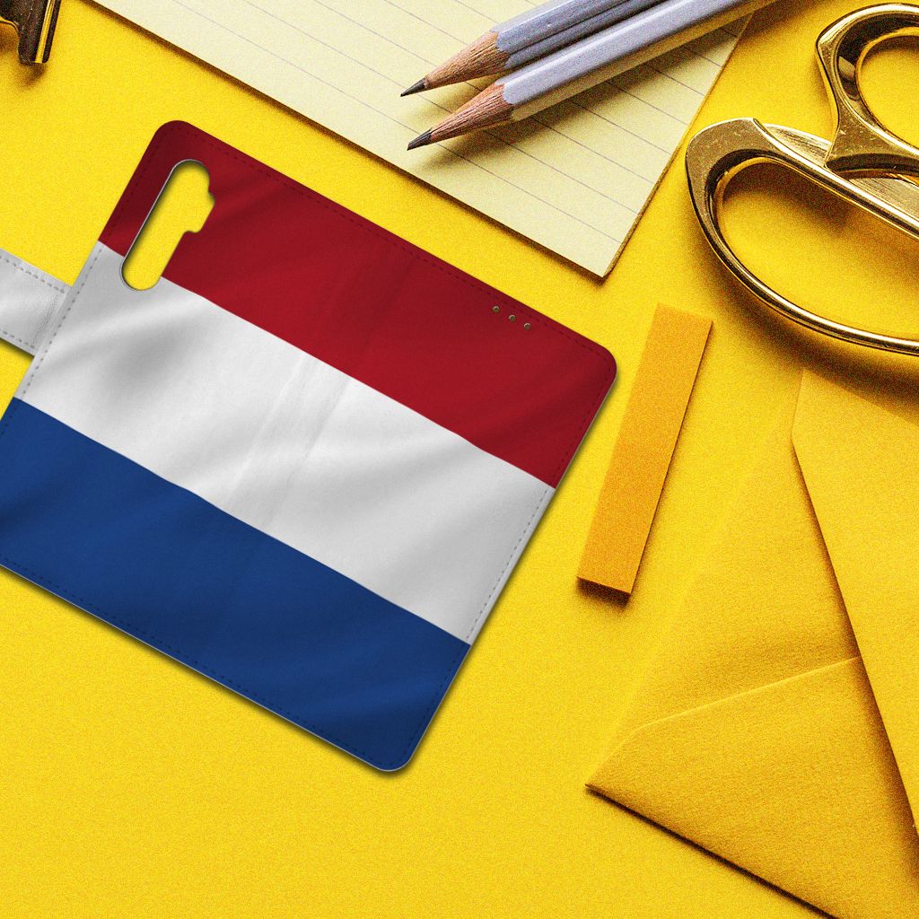 Xiaomi Mi Note 10 Lite Bookstyle Case Nederlandse Vlag met artistiek design op bureau met kantoorbenodigdheden.