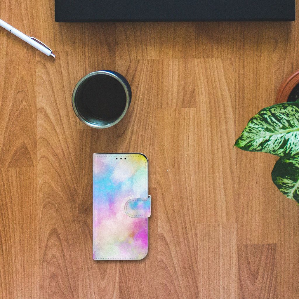 Hoesje iPhone 13 Mini Watercolor Light op een houten tafel met een kopje koffie en planten.