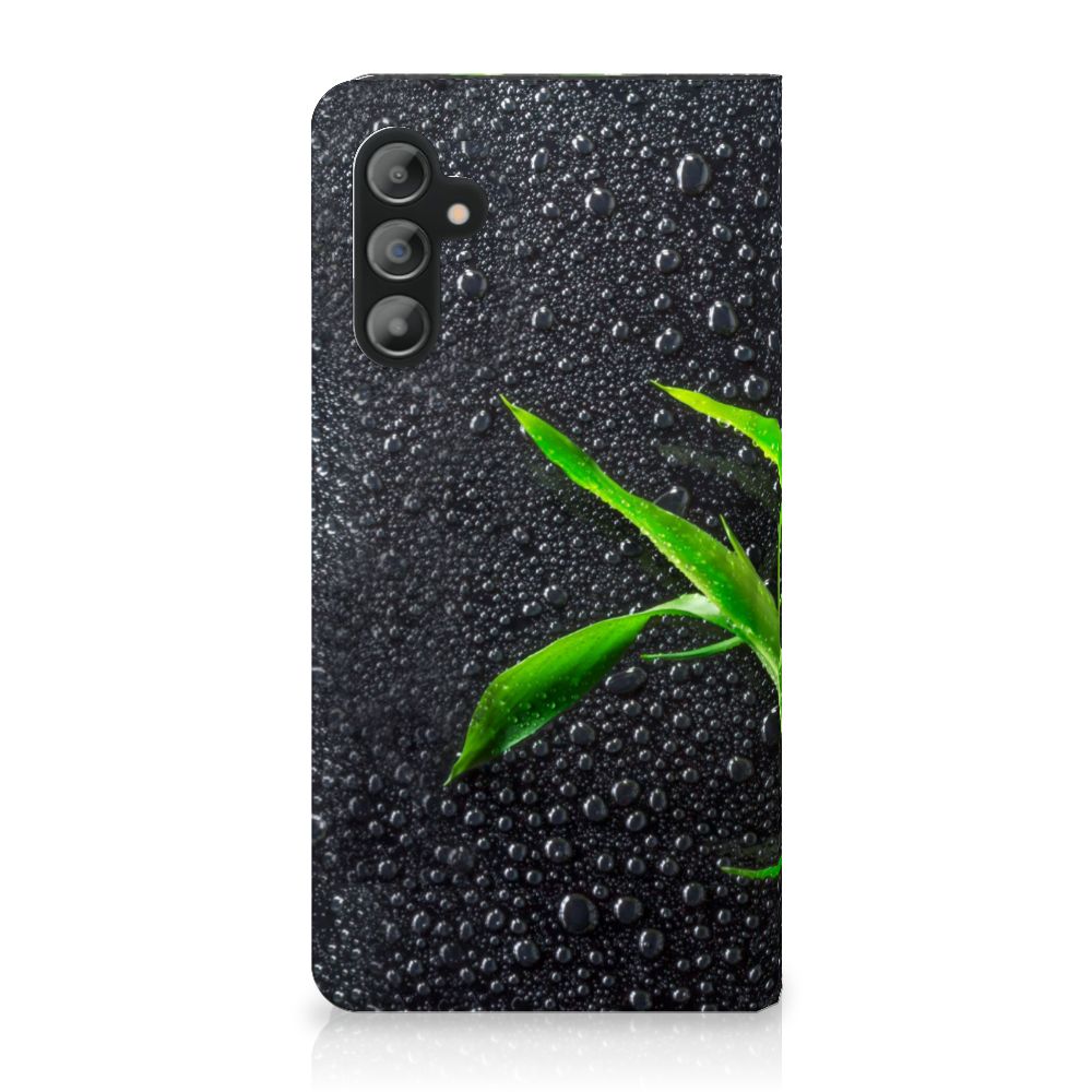 Samsung Galaxy A14 5G Smart Cover Orchidee met groene bladeren en waterdruppels op zwarte achtergrond.