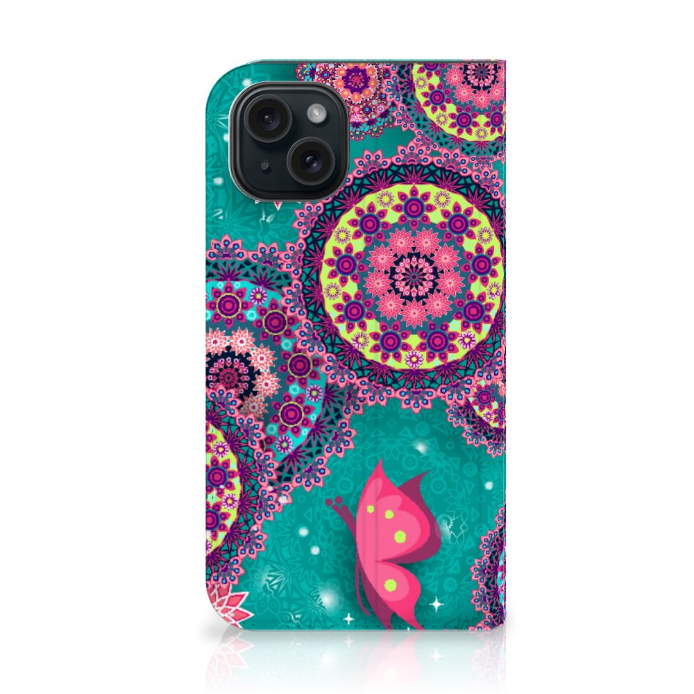 iPhone 15 Bookcase Cirkels en Vlinders met kleurrijke cirkels en vlinders op een turquoise achtergrond.