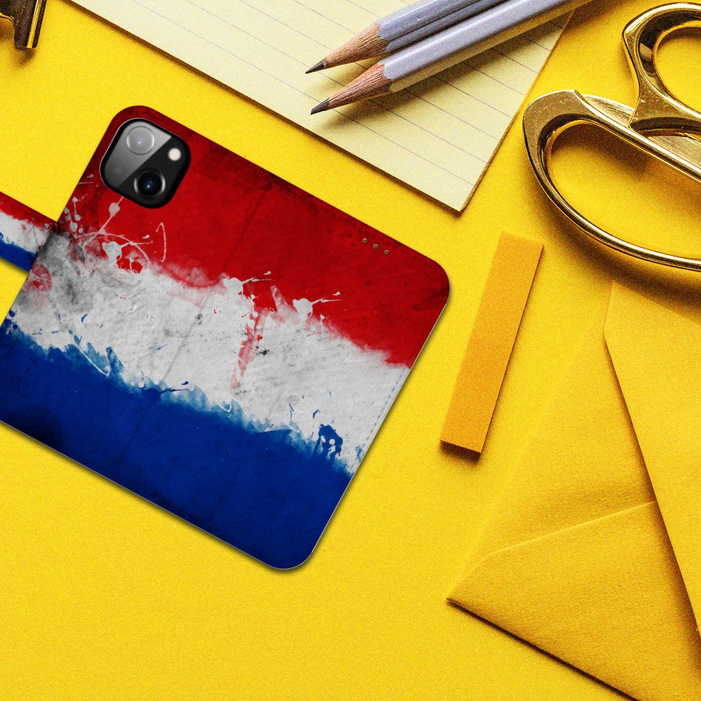 Apple iPhone 14 Bookstyle Case Nederland met artistieke weergave van de Nederlandse vlag op een bureau.