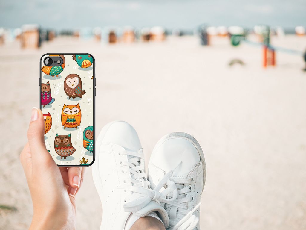 iPhone SE 2022 | SE 2020 | 7/8 Dierenprint Telefoonhoesje Vrolijke Uilen in een hand op het strand met sneakers.