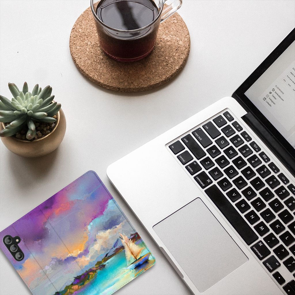 Bookcase Samsung Galaxy A14 5G Boat design with colorful landscape, placed next to a laptop and coffee.