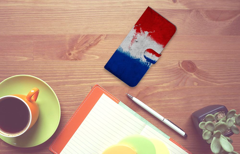 Motorola Moto G54 Bookstyle Case Nederland met artistiek design van de Nederlandse vlag op een houten tafel.