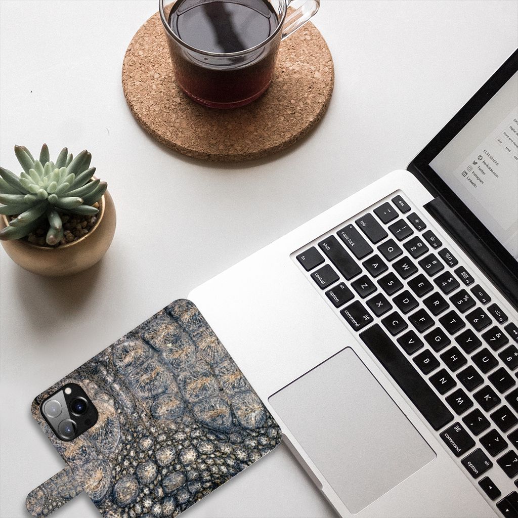 iPhone 14 Pro Telefoonhoesje met Pasjes Krokodillenprint op een bureau met een laptop en een kopje koffie.