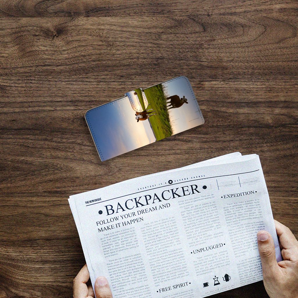 Samsung Galaxy A14 4G Telefoonhoesje met Pasjes Koe op een houten tafel met open krant eronder