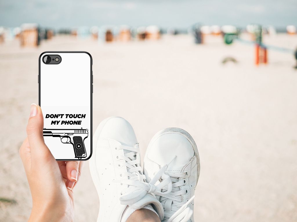 iPhone SE 2022 | SE 2020 | 7/8 Telefoon Hoesje Pistol DTMP op een hand met sneakers op een strand.