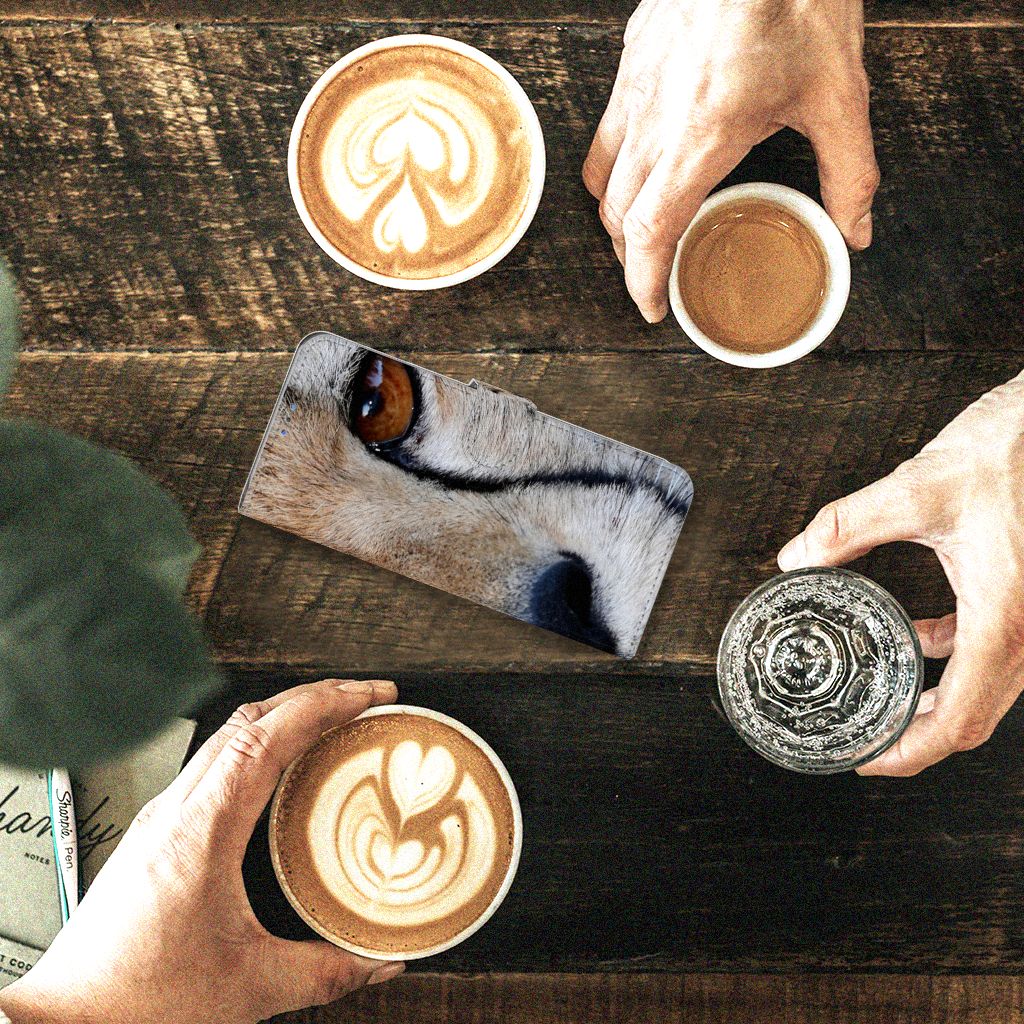 Motorola G8 Power Lite Telefoonhoesje met Pasjes Cheetah op een houten tafel met koffie.